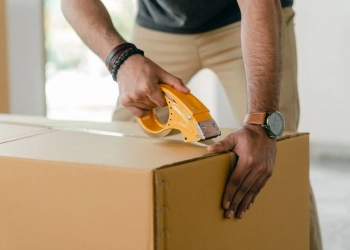 personne préparant son carton pour le déménagement