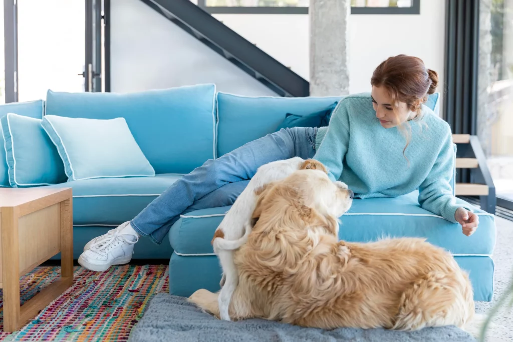 Une femme avec un mignon chien sur son tapis à l'intérieur. 