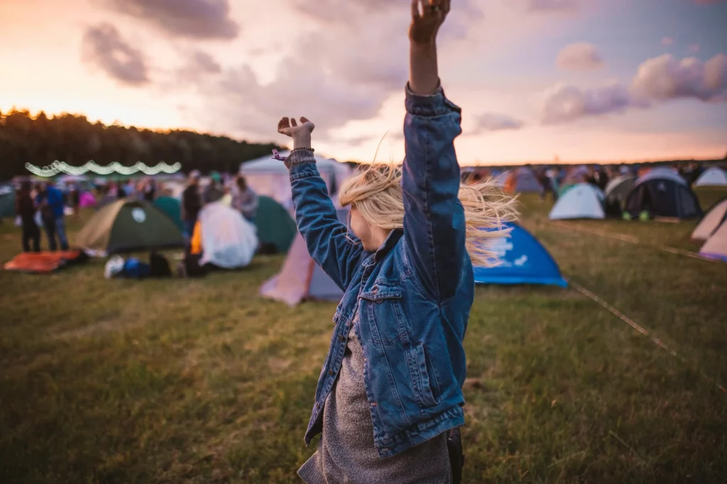 Femme faisant la fete dans un festival devant plusieurs tentes
