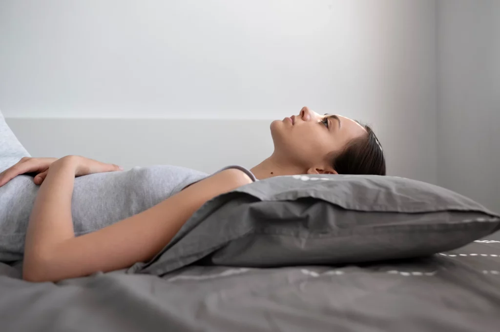Jeune femme allongée dans son lit avec un esprit apaisé