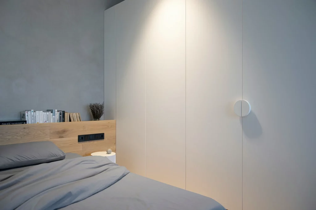 Chambre grise éclairée grâce à une lampe murale 