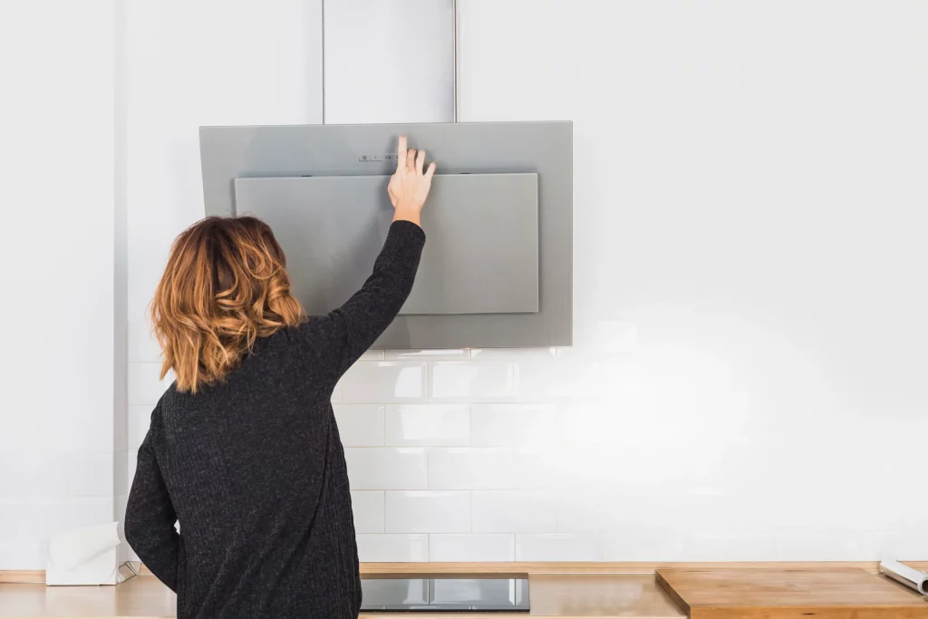 Hotte de cuisine ouverte par une femme