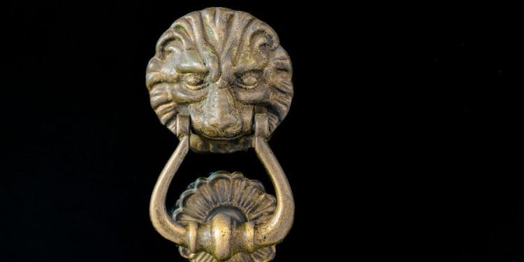 Heurtoir de porte en tête de lion en laiton antique sur fond noir